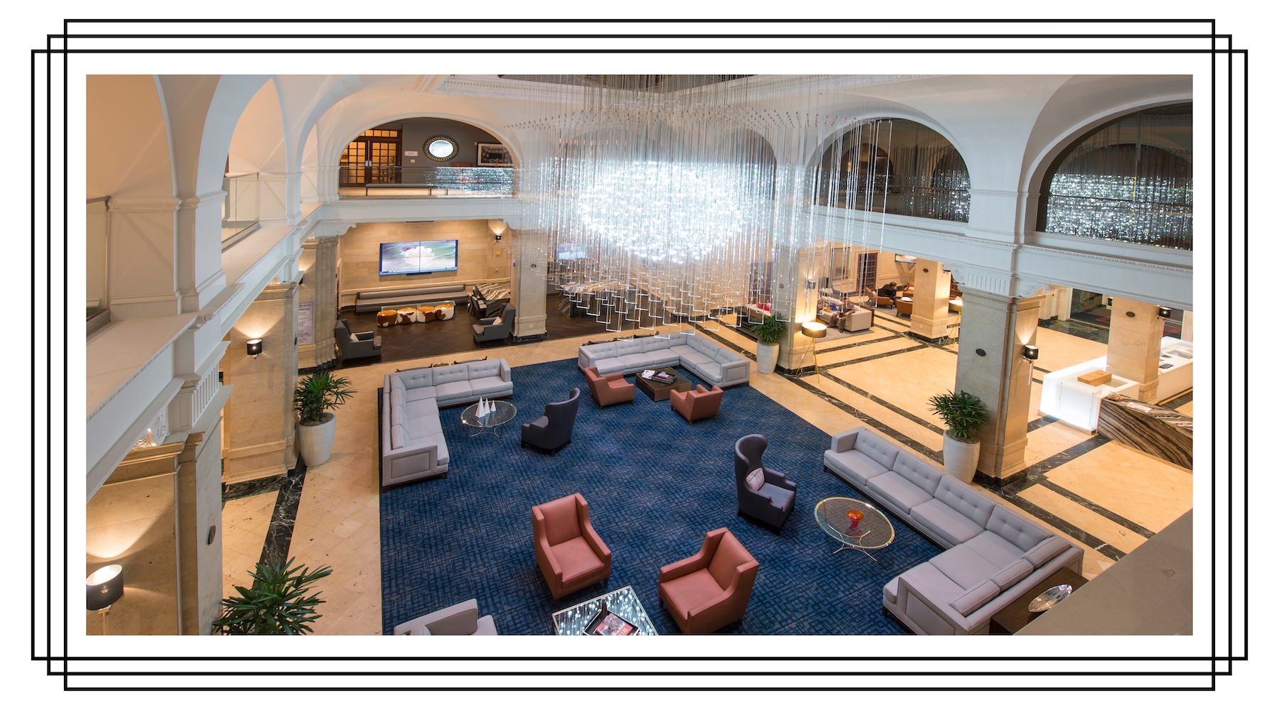 an aerial view of a clubroom with a chandelier and couches